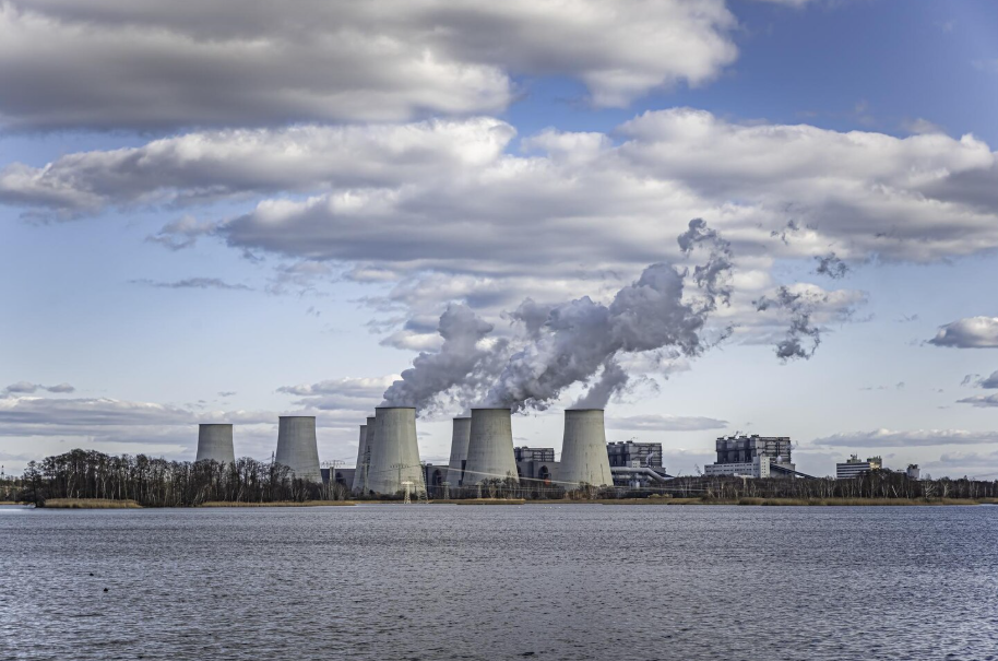 Nuclear power plant with cooling towers releasing steam, illustrating modern low-carbon electricity generation.
