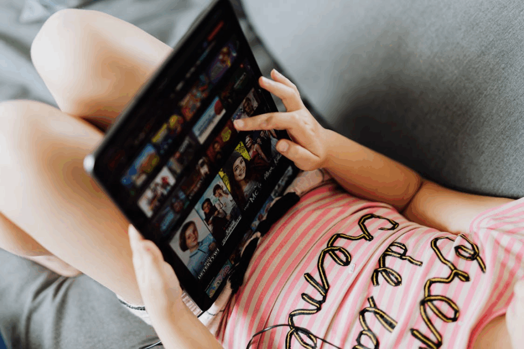 Person browsing a streaming platform on a tablet, showing how global streaming services shape viewing habits.